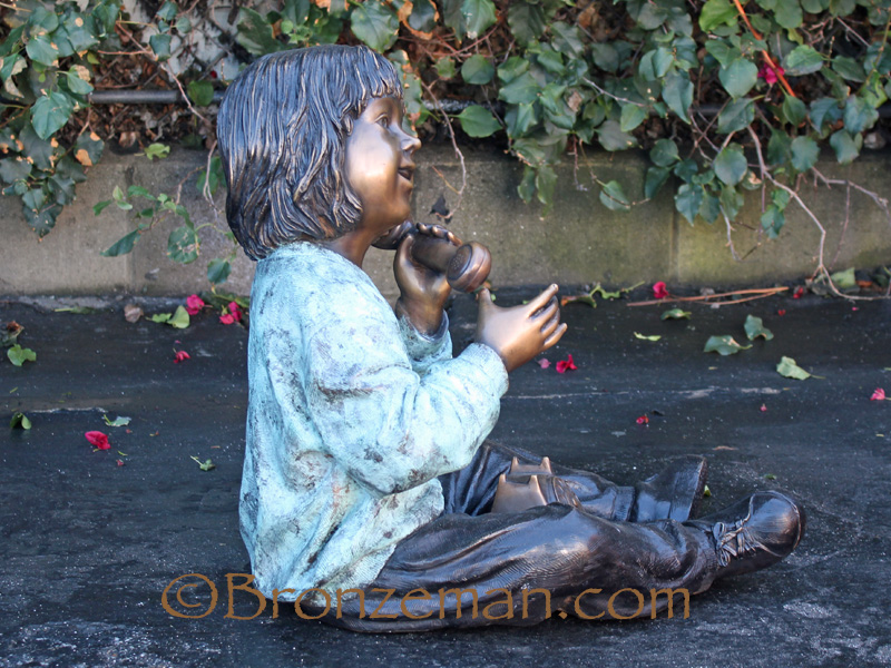 bronze statue of a girl talking on the phone