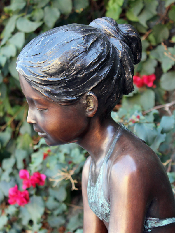bronze statue of a girl with a frog