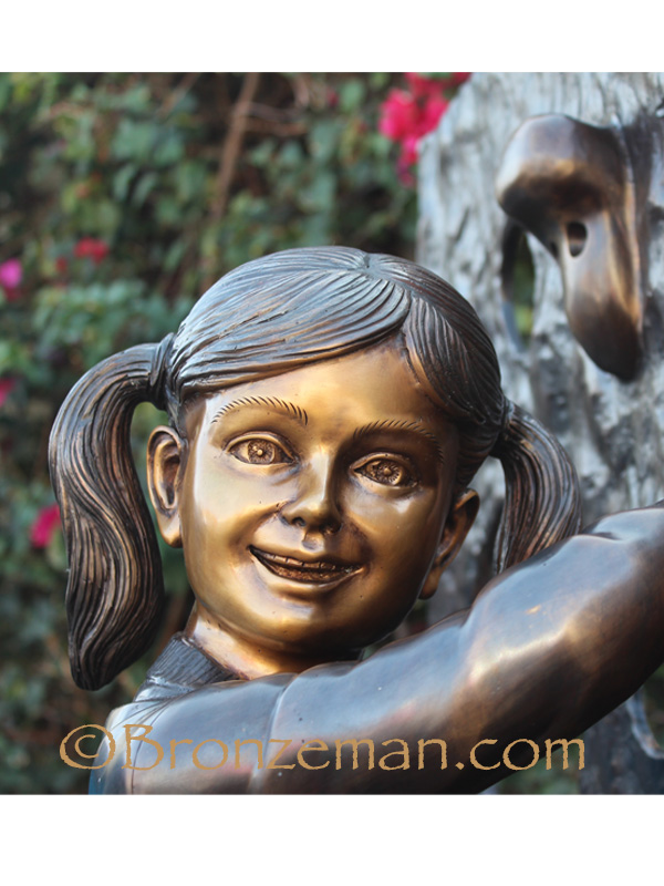 bronze statue of a girl rock climbing
