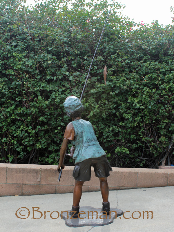bronze statue of a boy fishing