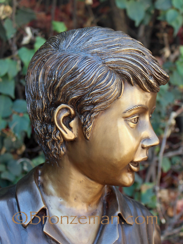bronze sculpture of a boy with a shovel and map