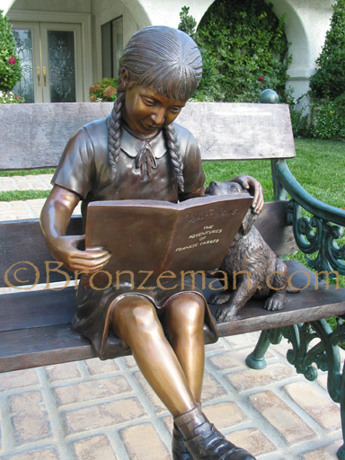 book statue of girl reading on bench