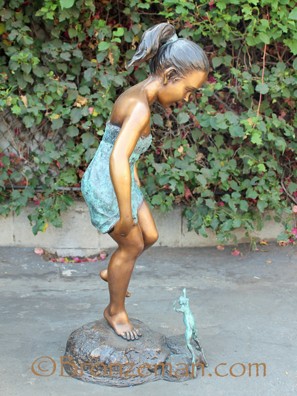 bronze statue of girl with frog