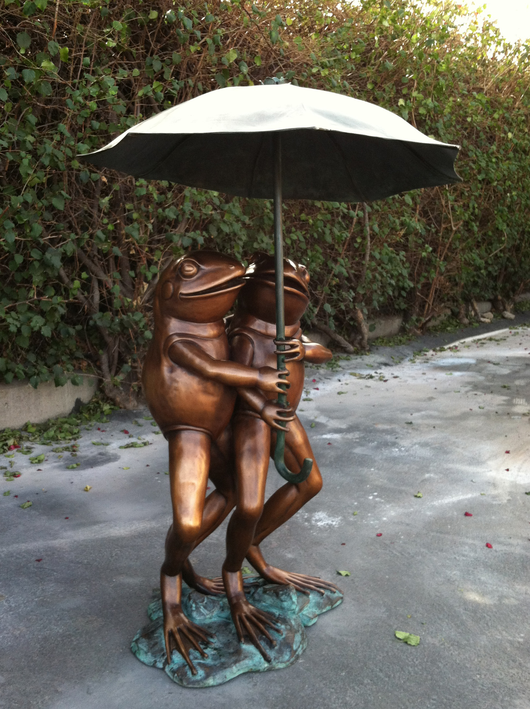 bronze statue of frogs under umbrella