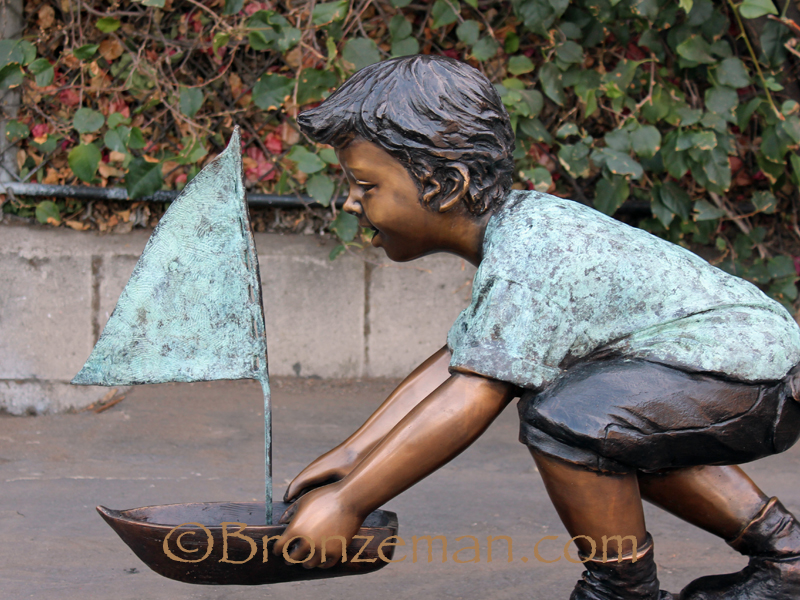 bronze statue of a boy with a sailboat