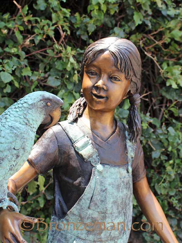 bronze statue of a girl with parrot