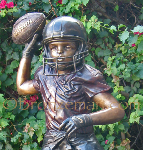 bronze statue of a boy playing football