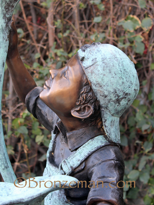 bronze statue of boy with flower