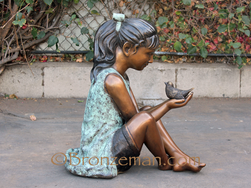 bronze statue of a girl and bird