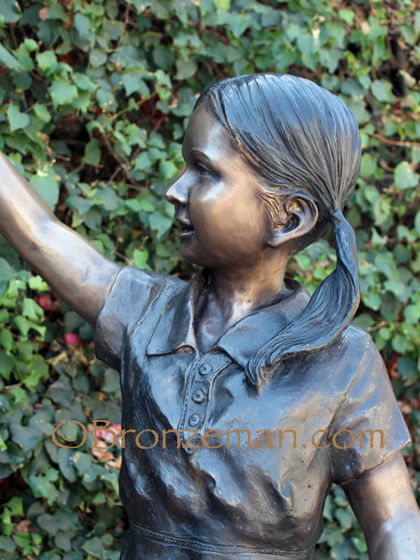bronze statue of a girl holding a bird