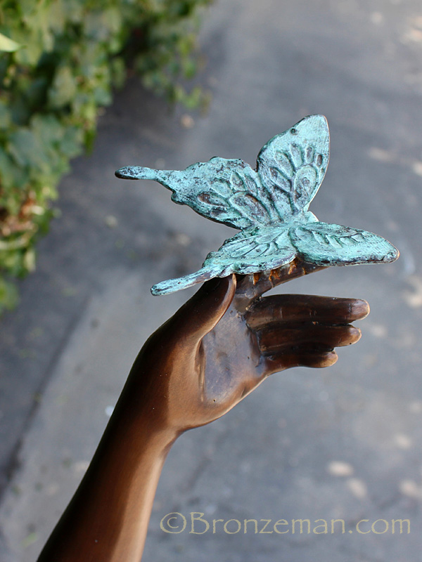 bronze statue of a girl with butterfly