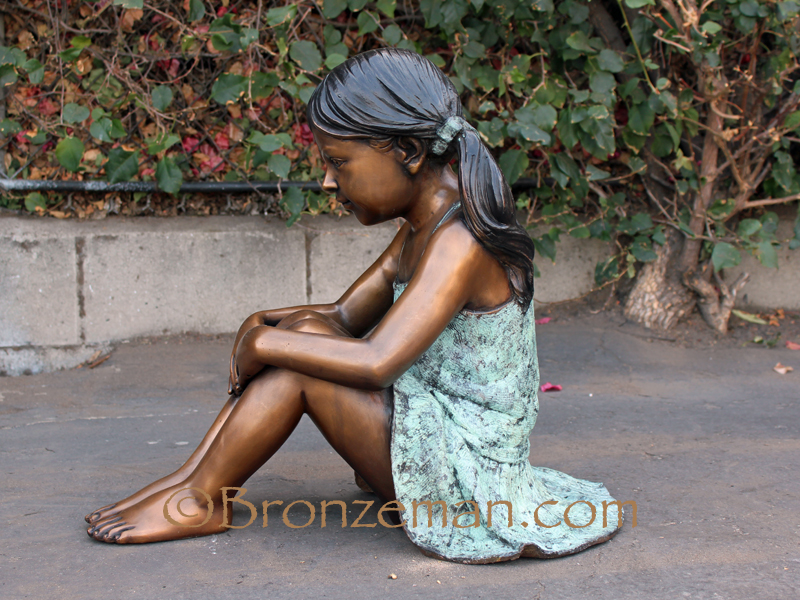 bronze statue of a girl sitting