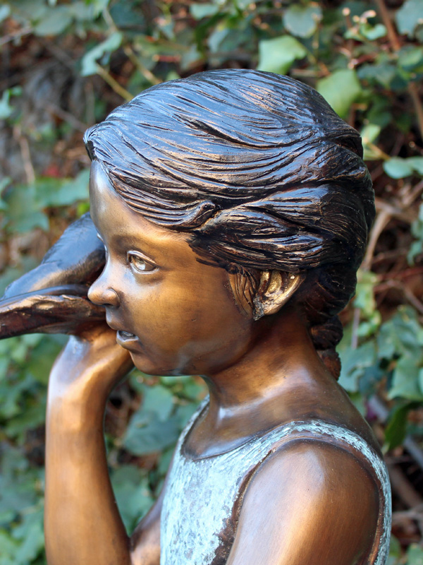 bronze statue of a girl holding a shell