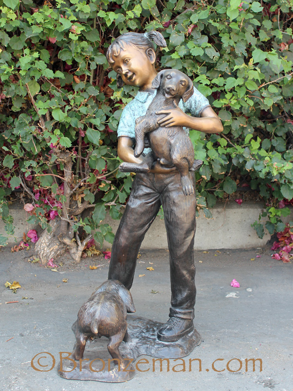 bronze statue of girl with dogs