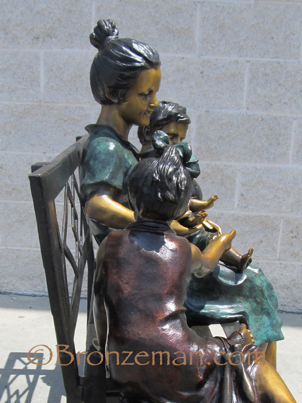 bronze statue of mom and children on bench