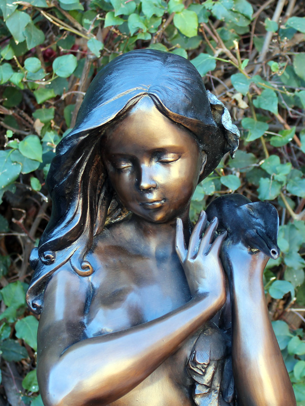 bronze fountain statue of girl holding a shell