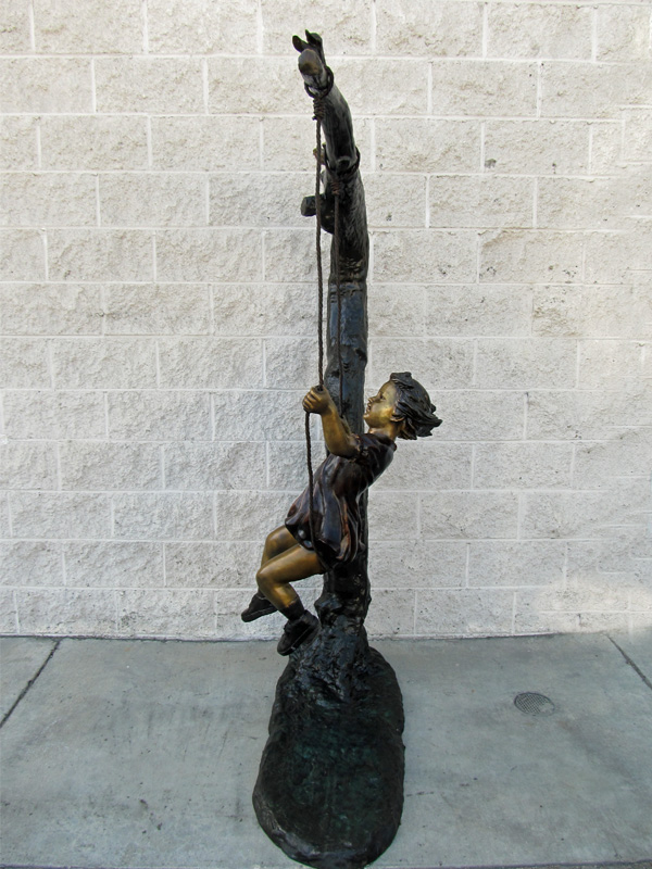 bronze statue of a girl swinging