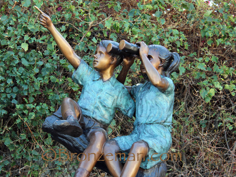 bronze statue of children playing in a tree