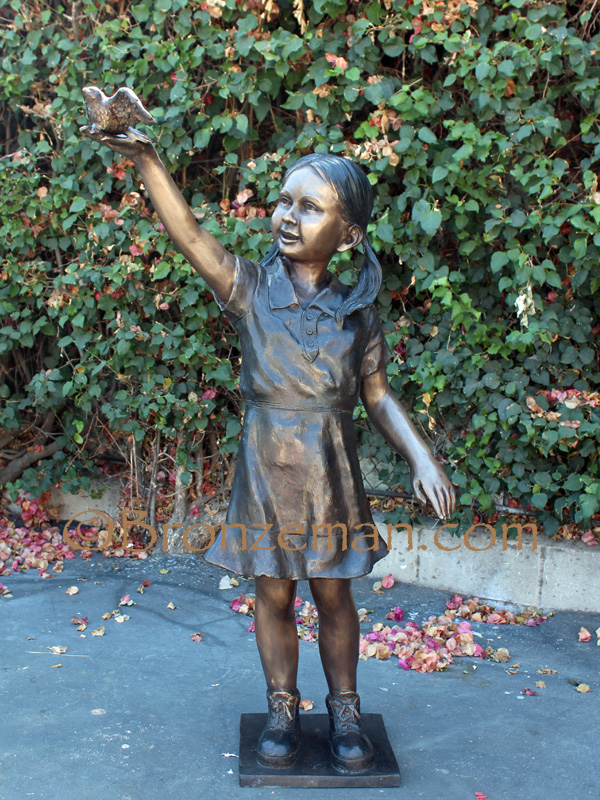 bronze statue of a girl holding a bird
