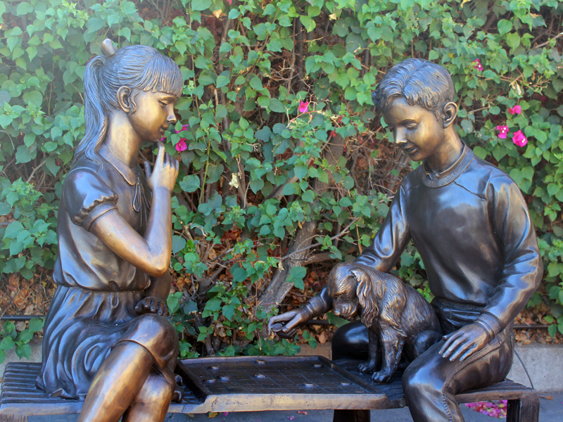 bronze statue of children playing checkers