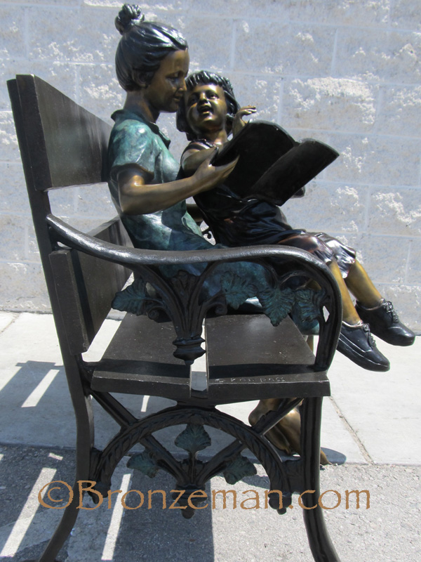 bronze statue of mother and daughter on bench