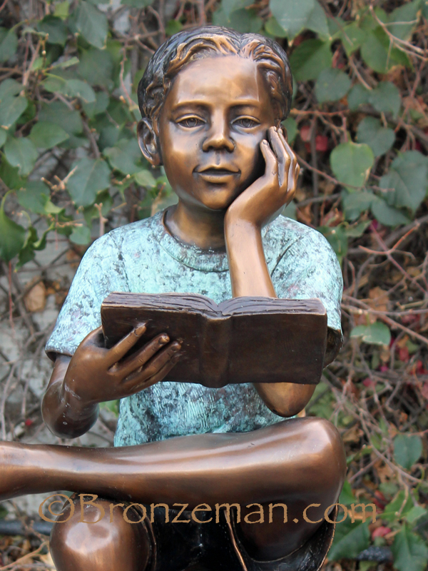 bronze statue of boy reading