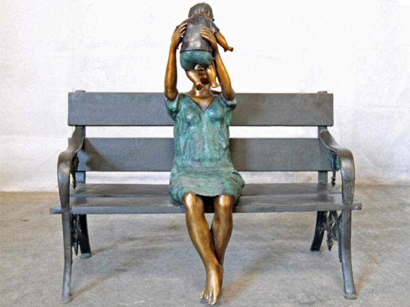 bronze statue of a mother and baby on bench