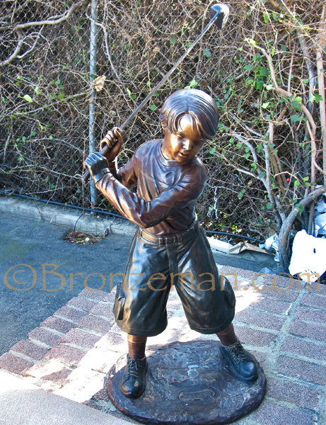 bronze statue of a boy golfer