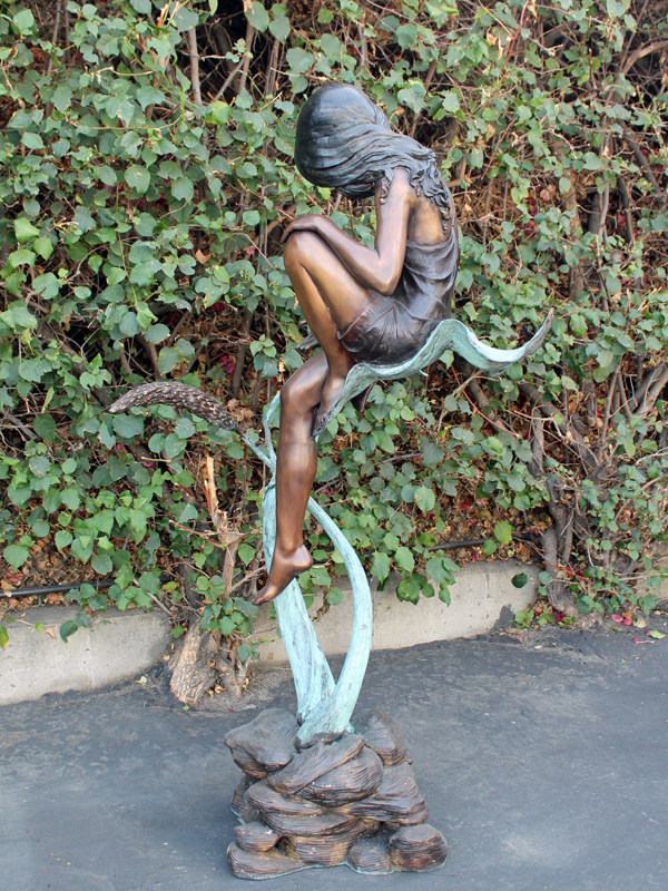 bronze statue of a girl sitting on a leaf