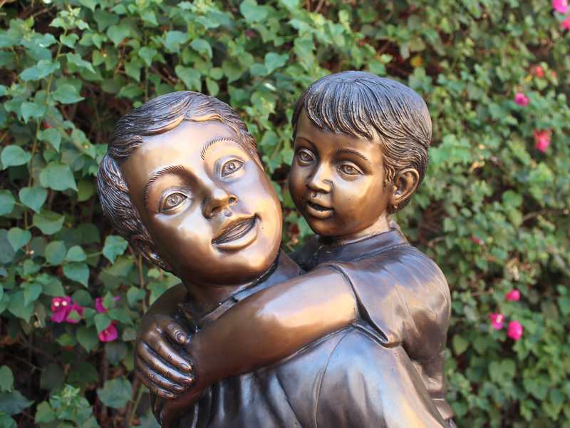 bronze statue of children playing piggyback