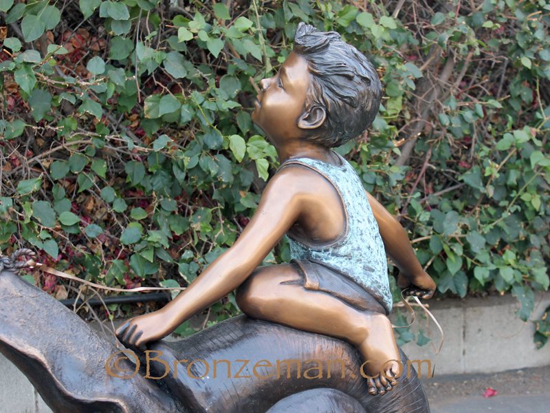 bronze statue of a boy riding a snail
