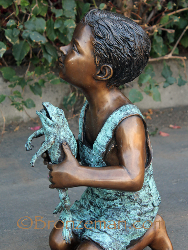 bronze statue of boy with frog