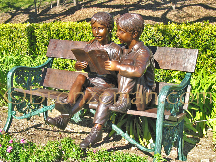 bronze sculpture of children reading on a bench
