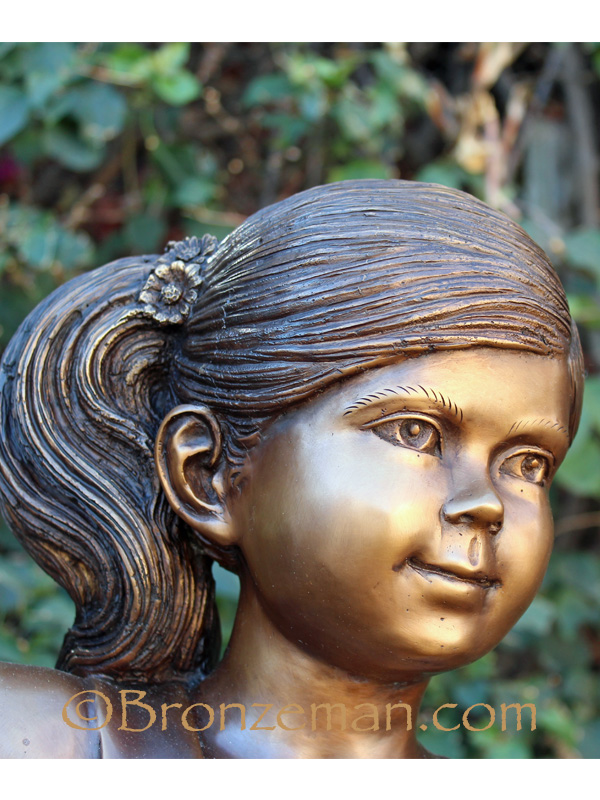 bronze statue of girl in swing