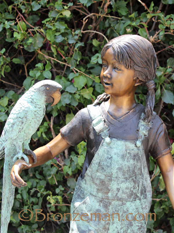 bronze statue of a girl with parrot