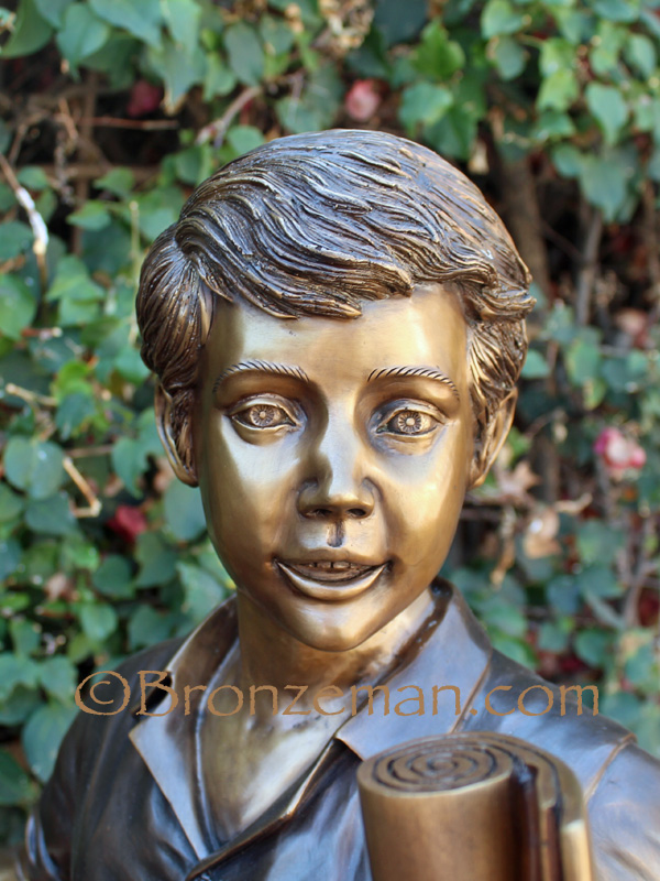 bronze sculpture of a boy with a shovel and map
