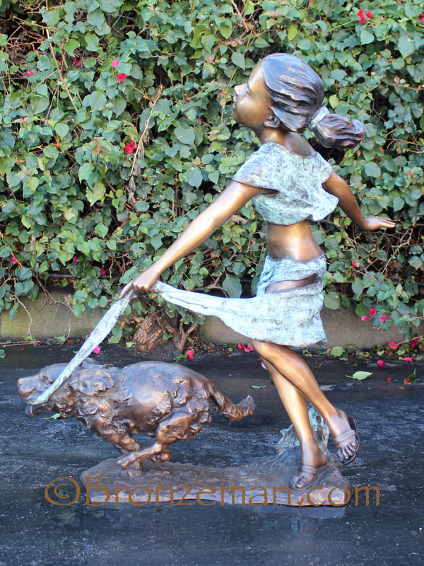 bronze statue of girl with dog