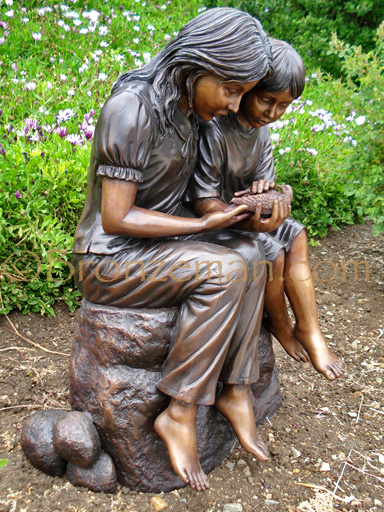 bronze statue of 2 girls with bird