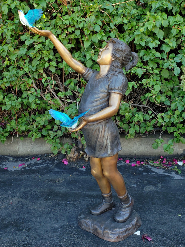 bronze statue of a girl with birds