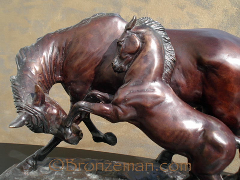 bronze statue of two horses playing