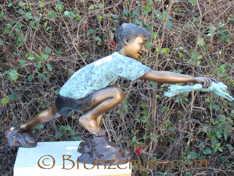 bronze statue of boy with frog