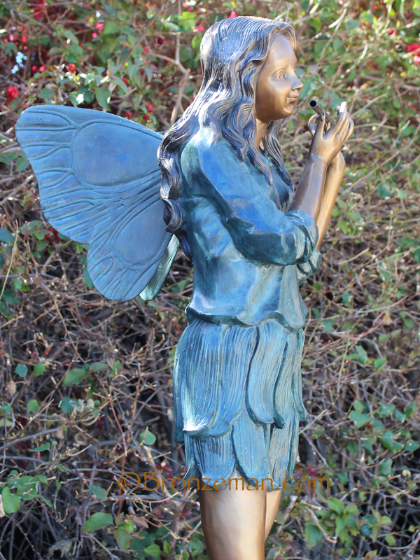 bronze statue of a fairy playing the flute