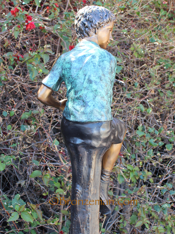 bronze statue of boy on stump
