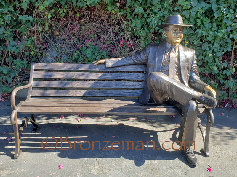 custom bronze statue of man sitting on bench