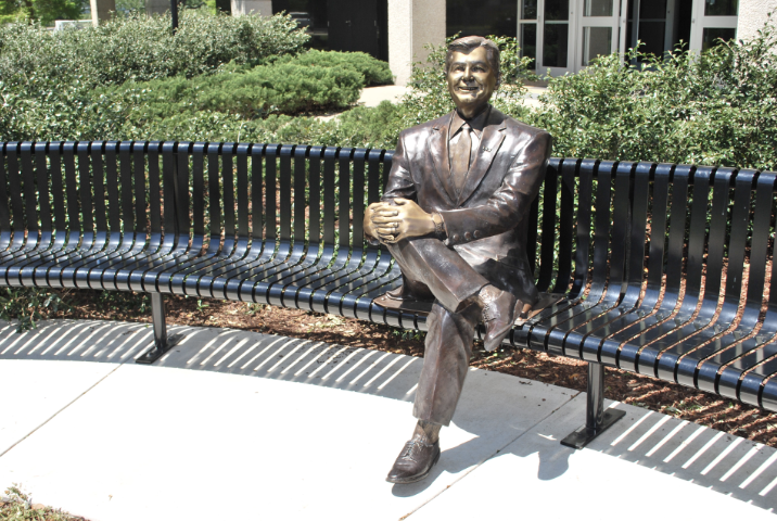 custom bronze statue of man on bench