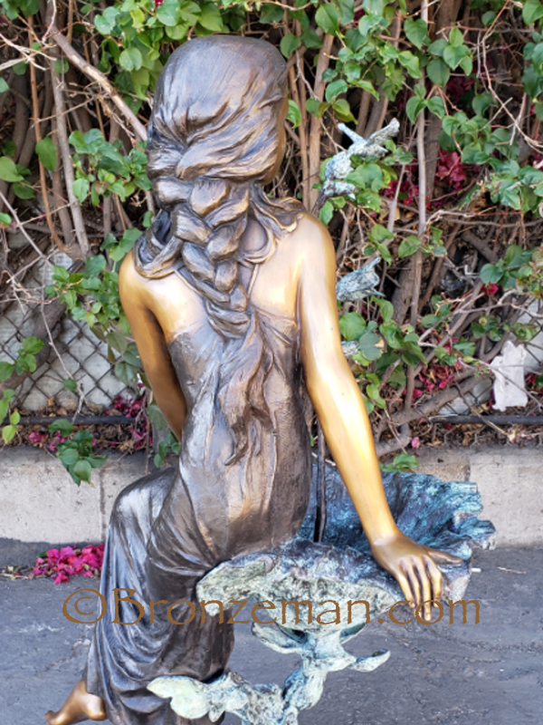 bronze statue of girl on birdbath