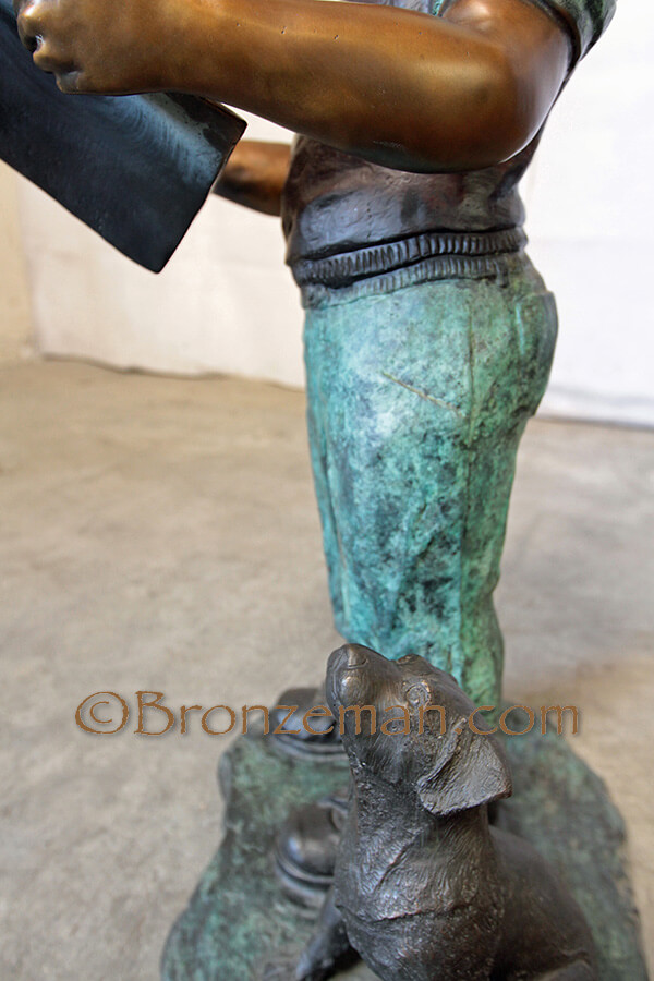 bronze statue of boy reading to his dog