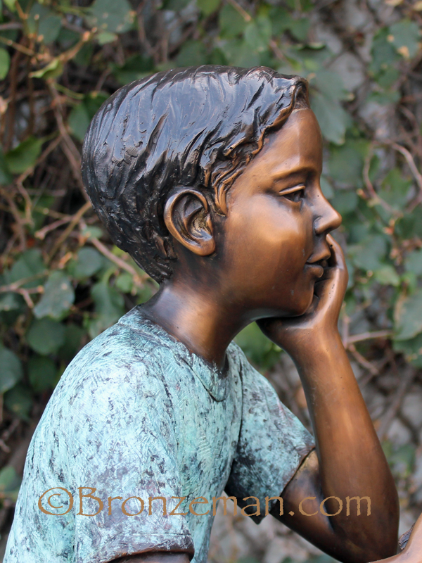 bronze statue of boy reading
