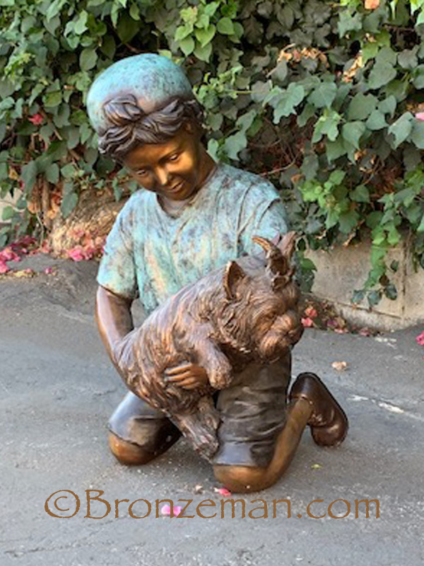 bronze statue of a boy holding a dog