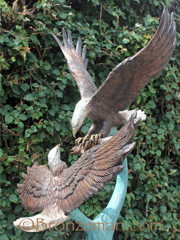 2 bronze eagles fighting over food